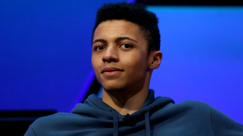 Myth wearing a blue hoodie and looking straight into the camera