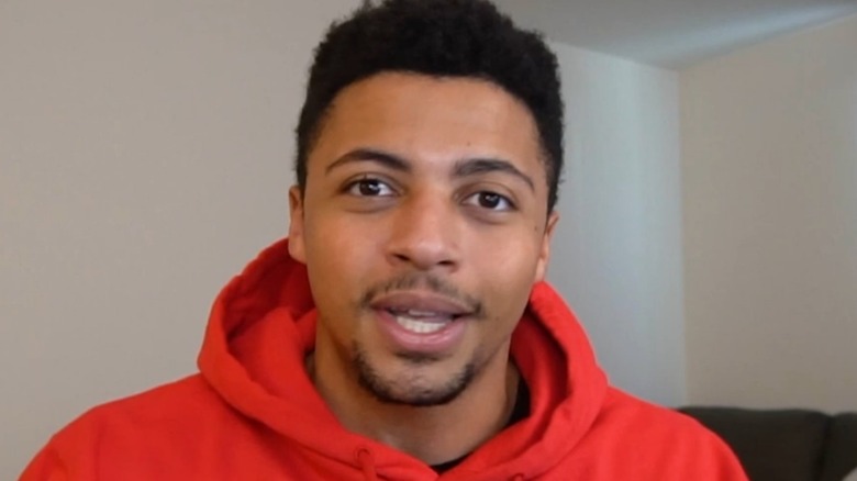 Myth wearing a red hoodie