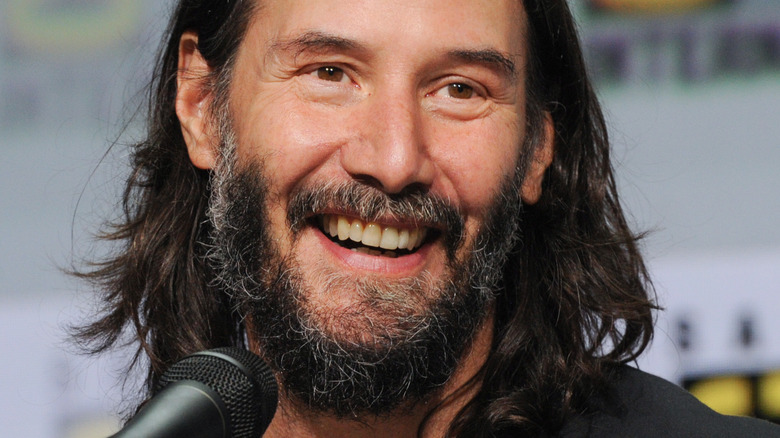 Keanu Reeves smiling at Comic Con panel