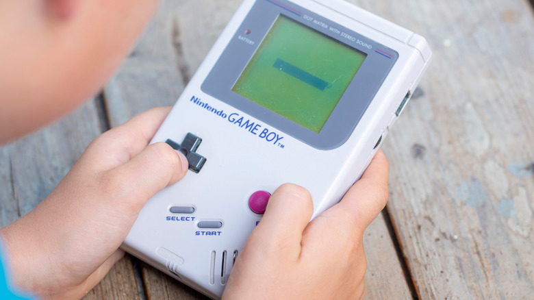 A child playing on a Game Boy.