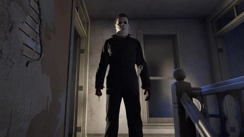 Michael Myers stands holding a knife at the top of a staircase in Halloween: The Game