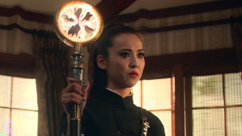 Nico holding her staff