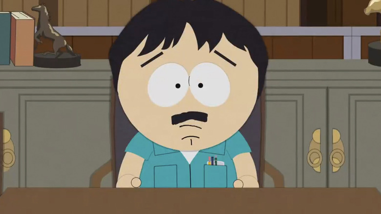 Randy Marsh sits in a chair and stares down the camera lens in South Park