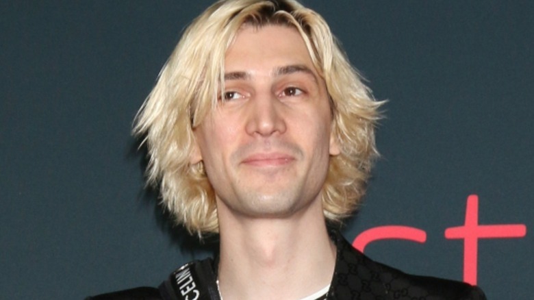 xQc in front of a gray background