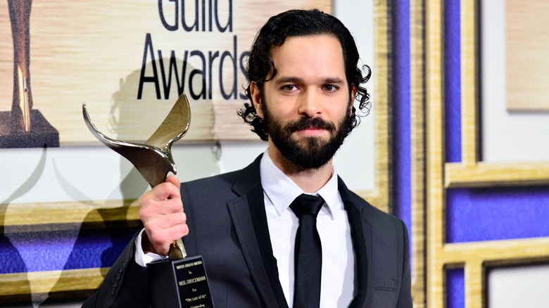 Neil Druckman holding a Writers Guild Award