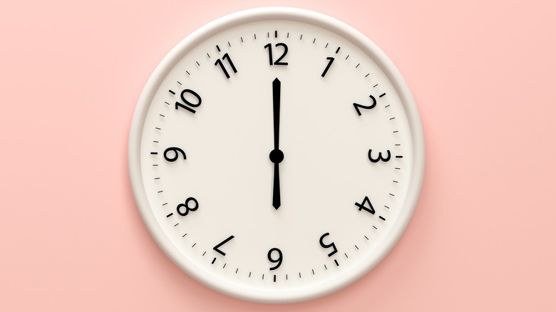 Analog clock against light pink wall