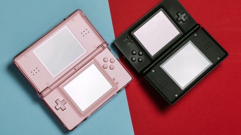 Pink and black Nintendo 3DS next to each other