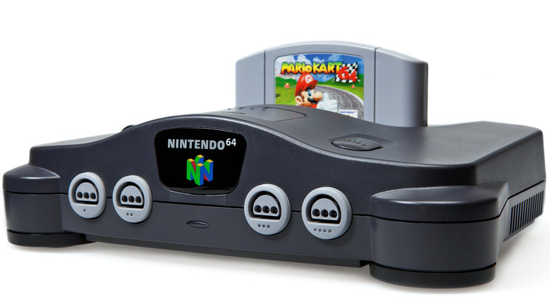 A Nintendo 64 console against a white background. A Mario Kart 64 cartridge is inserted into the system.