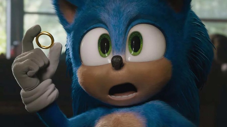Sonic holds a ring in his hand and looks at the camera in surprise