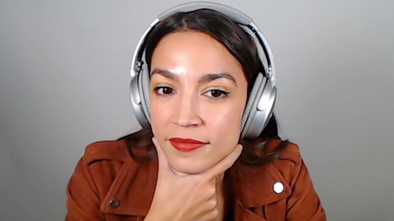 AOC with hand under chin