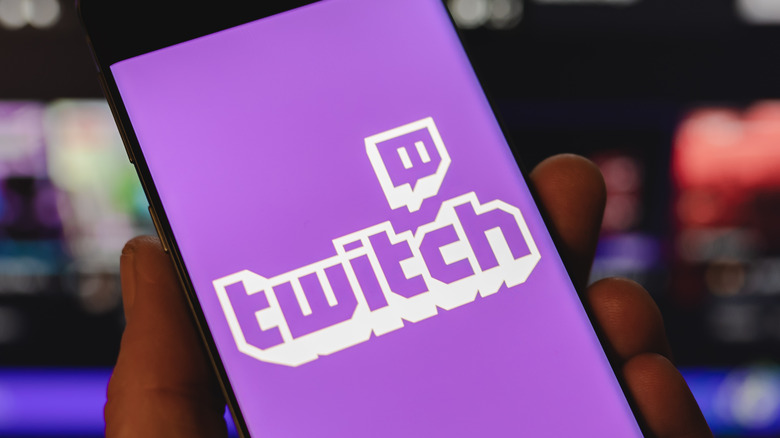 A phone being held with the Twitch logo on it
