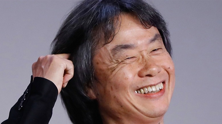 Shigeru Miyamoto pointing at head