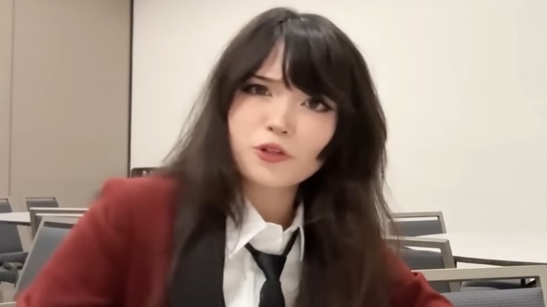 Emiru wearing red suit and black tie