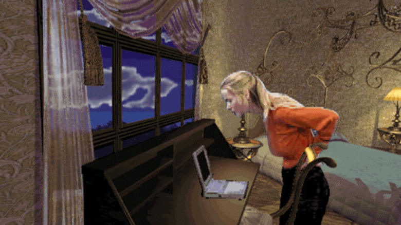 Adrienne Delaney examines a laptop on a desk by a window in Phantasmagoria