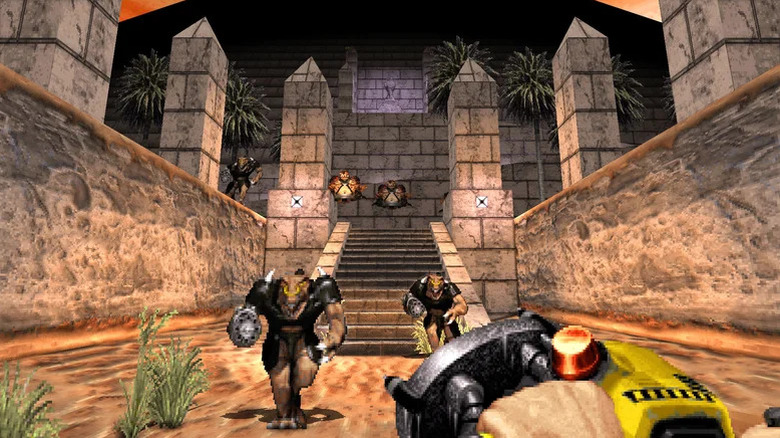 Duke Nukem aims a futuristic weapon at approaching aliens in Duke Nukem 3D