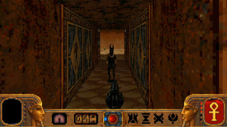 The player character points a pistol at a jackal-headed monster in PowerSlave