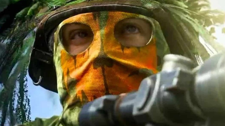 Sniper wearing camouflaged mask and helmet