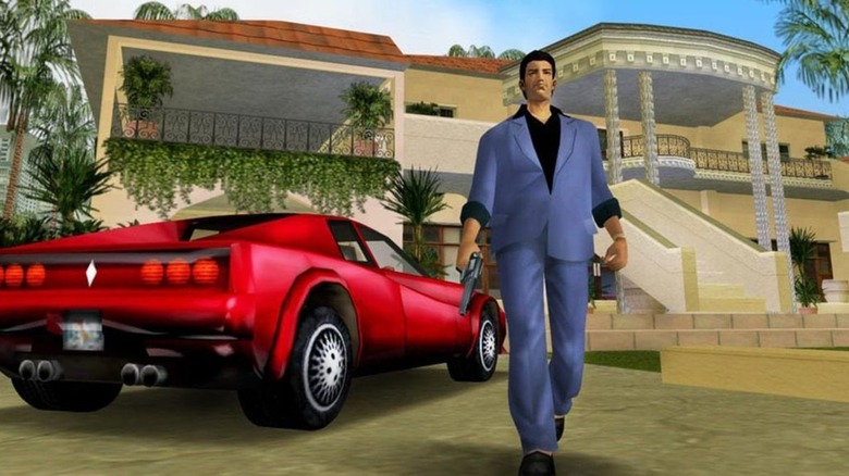 Tommy wearing suit and holding gun by car