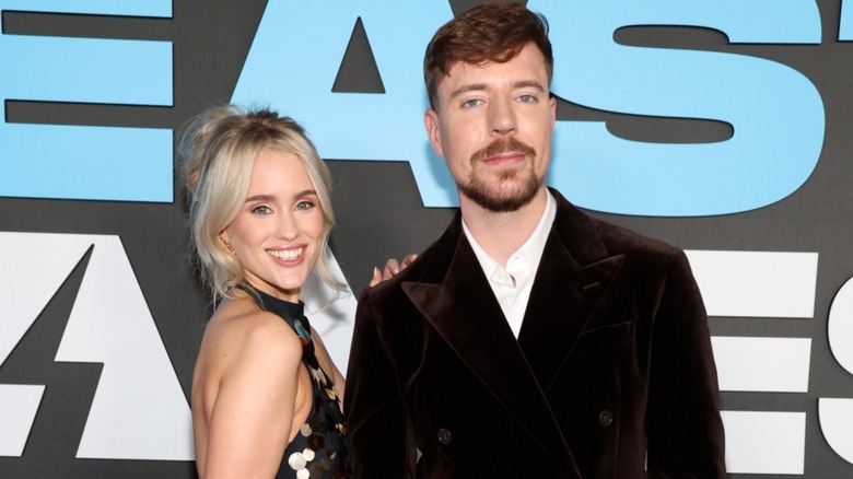 Thea Booysen and MrBeast posing in front of Beast Games sign