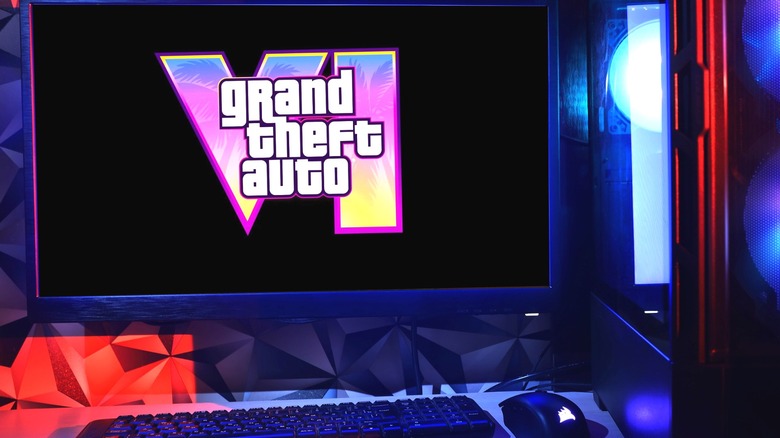 A keyboard and mouse in front of a monitor displaying the Grand Theft Auto 6 logo