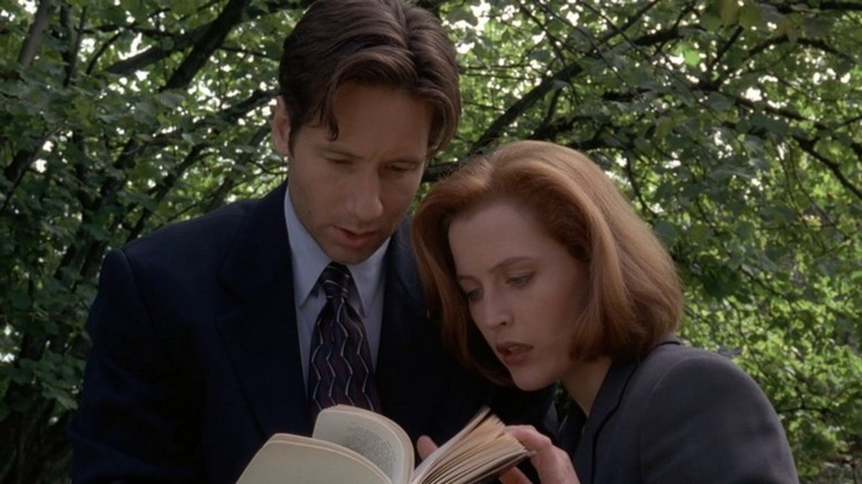 Mulder and Scully looking at book