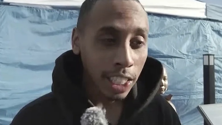 Johnny Somali talking into microphone