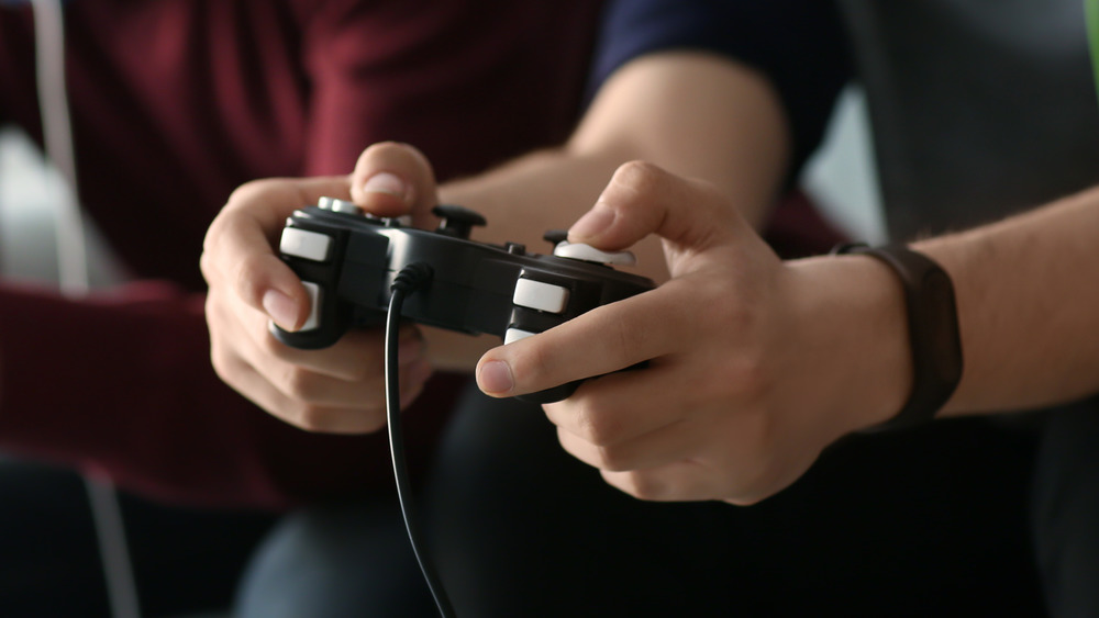 two young men play a video game